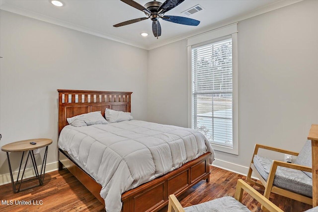 bedroom featuring ceiling fan, multiple windows, dark hardwood / wood-style flooring, and crown molding