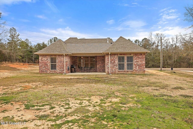 back of house with a patio area and a lawn