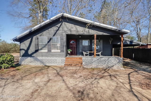 view of front of home featuring covered porch and fence