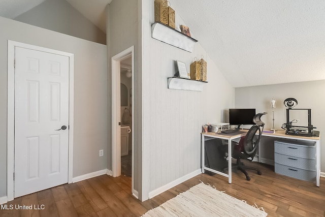 office featuring lofted ceiling, dark wood-type flooring, and a textured ceiling