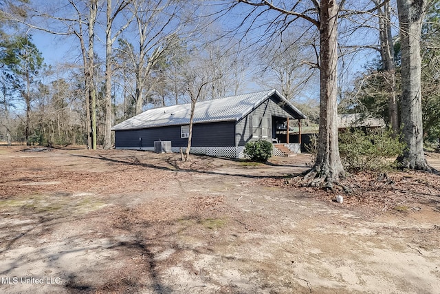 view of side of property with metal roof and central AC unit