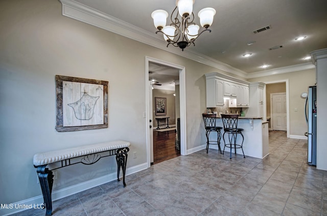 135 Mason Way, Madison, MS 39110 - kitchen featuring ornamental molding, a peninsula, a chandelier, a breakfast bar, and white cabinetry