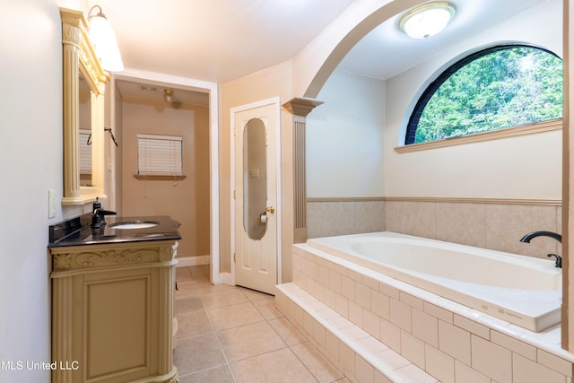 bathroom with tile patterned flooring, vanity, and a garden tub