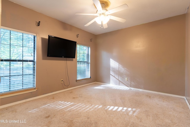 empty room with carpet flooring, baseboards, and a ceiling fan
