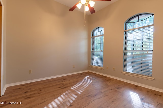 empty room with wood finished floors, ceiling fan, and baseboards