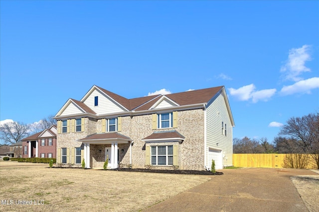 view of front of house with a front yard, concrete driveway, and fence