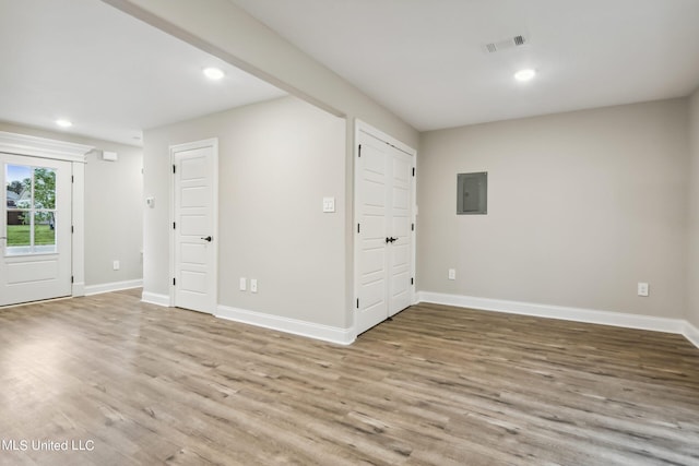 unfurnished room with hardwood / wood-style flooring and electric panel