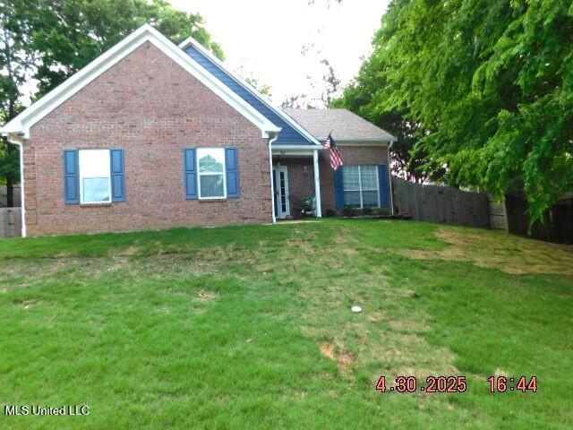 5881 Morganton Dr, Olive Branch, MS 38654 - rear view of house with a lawn, brick siding, and fence