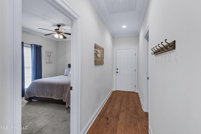 hall with ornamental molding and wood-type flooring