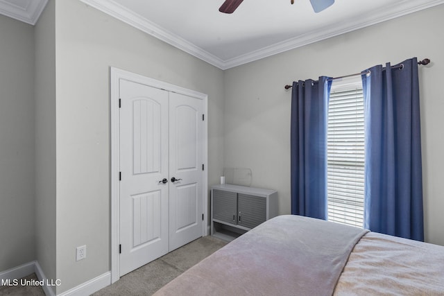 carpeted bedroom featuring ceiling fan, ornamental molding, and a closet