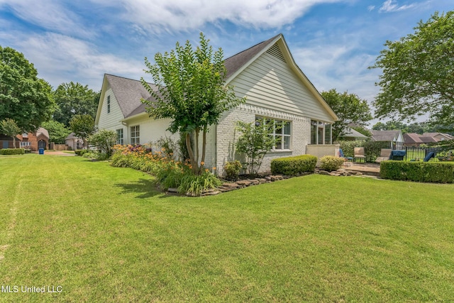 3831 Lake Village Cv, Olive Branch, MS 38654 - view of home's exterior with a yard, brick siding, a shingled roof, and a patio