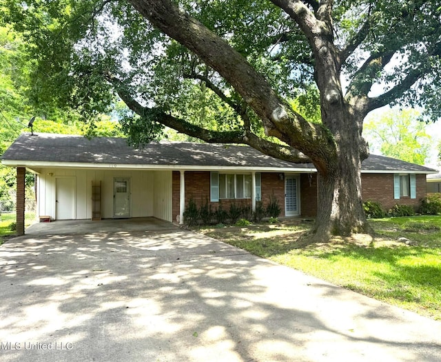 ranch-style house featuring concrete driveway, a carport, brick siding, and board and batten siding