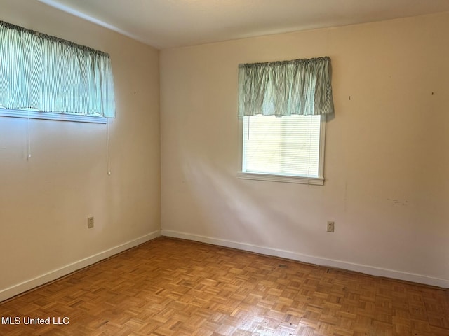 unfurnished room with baseboards