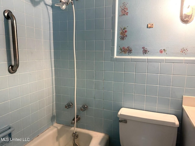full bath with toilet, shower / bath combination, and tile walls