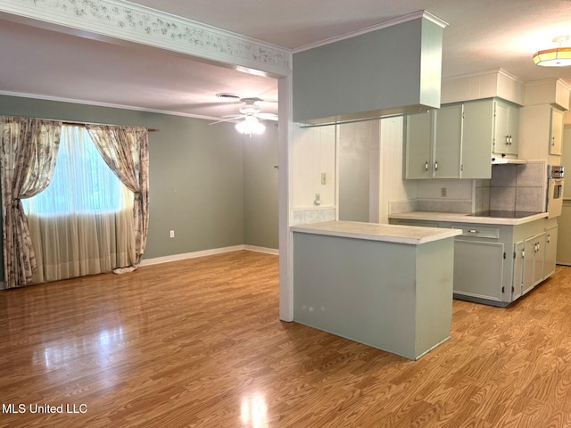 kitchen with a ceiling fan, crown molding, black electric cooktop, light countertops, and light wood-style floors
