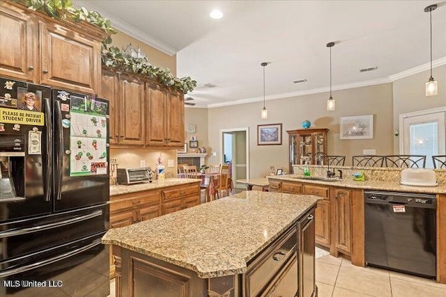 kitchen featuring a center island, sink, decorative light fixtures, black appliances, and ornamental molding