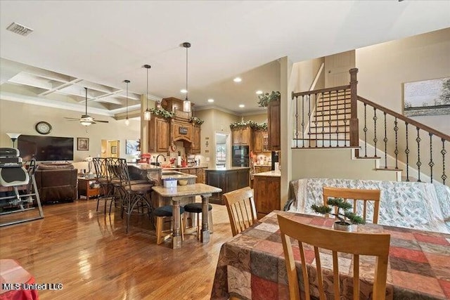 dining space with ornamental molding, coffered ceiling, ceiling fan, dark wood-type flooring, and beam ceiling