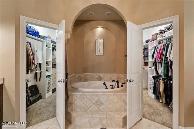 bathroom featuring tile patterned floors and tiled tub