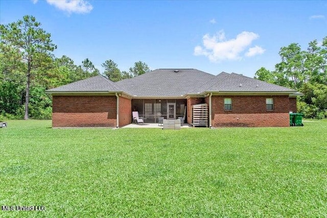 back of house with a sunroom, a patio, and a lawn