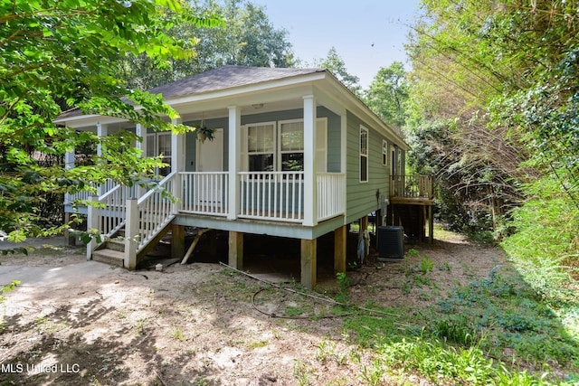 9726 Limu Pl, Diamondhead, MS 39525 - view of front of property featuring cooling unit, a porch, a shingled roof, and stairway