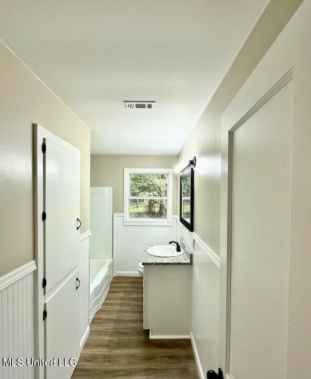 bathroom featuring vanity, hardwood / wood-style flooring, and toilet