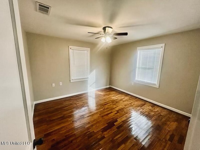 spare room with ceiling fan and dark hardwood / wood-style flooring