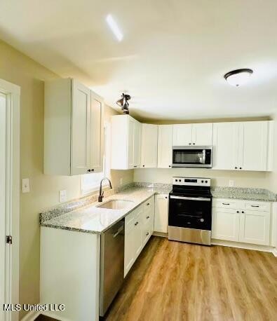 kitchen featuring white cabinetry, light hardwood / wood-style floors, stainless steel appliances, and sink