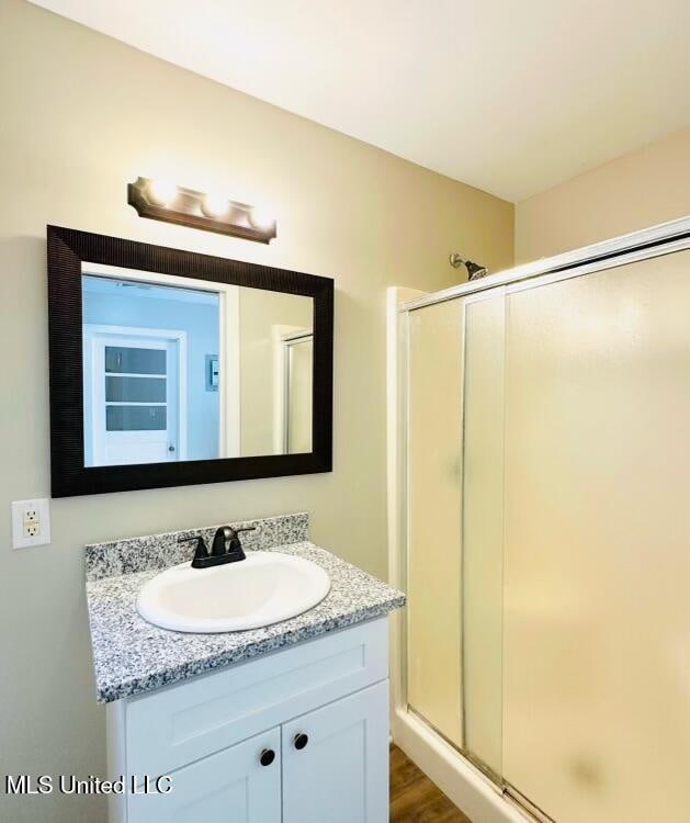 bathroom featuring vanity, a shower with shower door, and hardwood / wood-style floors