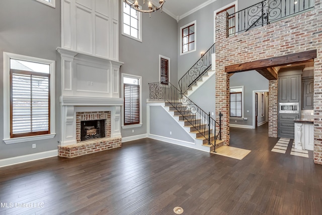 101 Commons Pl, Ridgeland, MS 39157 - unfurnished living room featuring baseboards, stairs, dark wood-style flooring, and a high ceiling