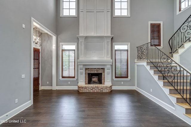101 Commons Pl, Ridgeland, MS 39157 - unfurnished living room with a brick fireplace, a healthy amount of sunlight, a high ceiling, and stairway