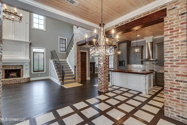 101 Commons Pl, Ridgeland, MS 39157 - kitchen with wood ceiling, a brick fireplace, butcher block counters, and wall chimney exhaust hood
