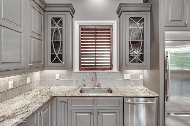 101 Commons Pl, Ridgeland, MS 39157 - kitchen with a sink, tasteful backsplash, glass insert cabinets, gray cabinetry, and appliances with stainless steel finishes