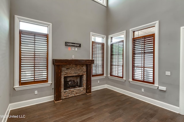 101 Commons Pl, Ridgeland, MS 39157 - unfurnished living room with baseboards, a stone fireplace, and dark wood-type flooring
