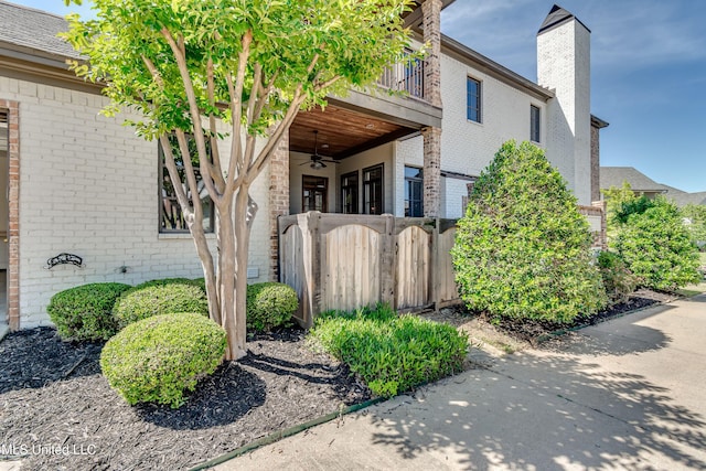 101 Commons Pl, Ridgeland, MS 39157 - exterior space with a chimney, fence, ceiling fan, a balcony, and brick siding