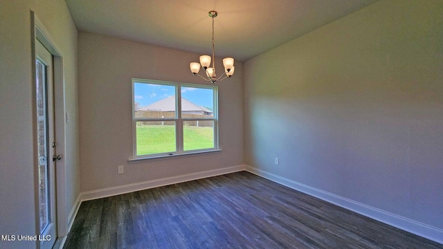 unfurnished room with baseboards, dark wood finished floors, and a chandelier