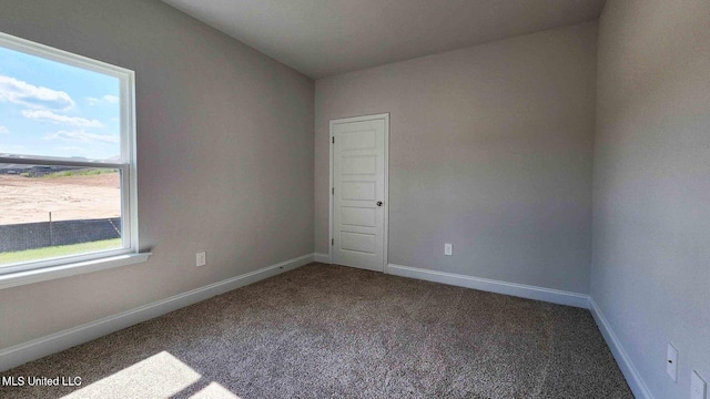 empty room with baseboards and carpet flooring