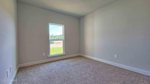 spare room featuring carpet and baseboards