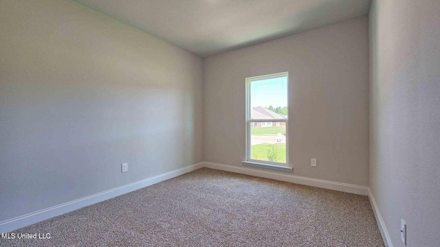 unfurnished room with carpet floors and baseboards