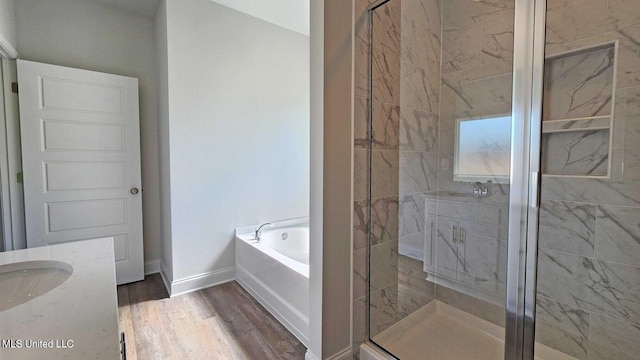 bathroom featuring a stall shower, wood finished floors, vanity, and a bath