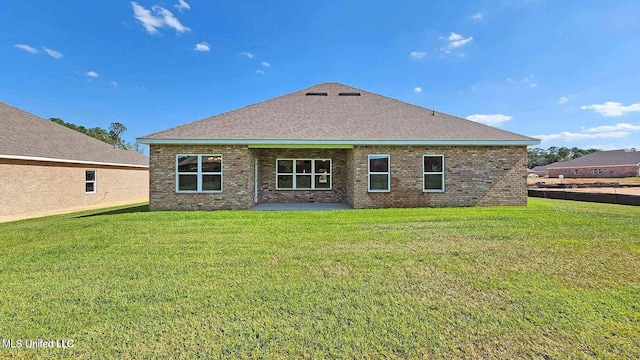 back of property with a shingled roof, a lawn, and brick siding