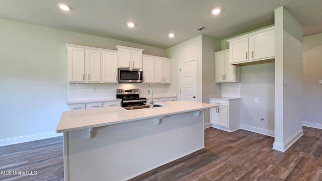 kitchen with stainless steel appliances, tasteful backsplash, a sink, and baseboards