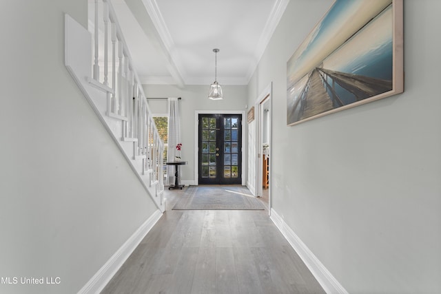 foyer with hardwood / wood-style floors, beam ceiling, crown molding, and french doors