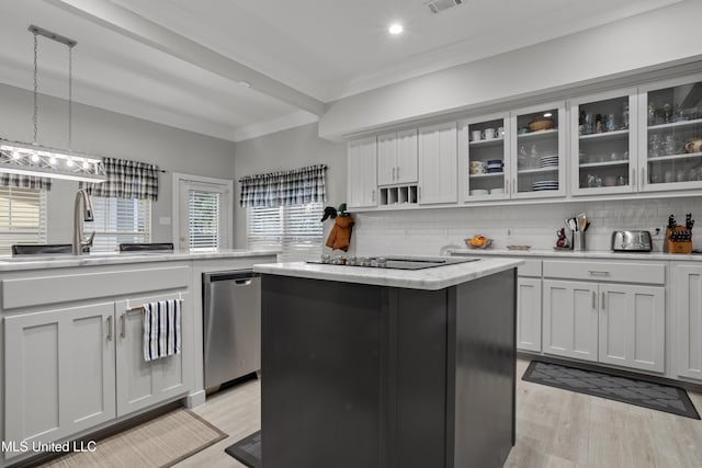 kitchen with a center island, backsplash, black electric stovetop, sink, and hanging light fixtures