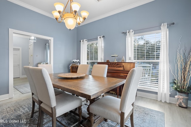 dining space with hardwood / wood-style flooring, ornamental molding, a healthy amount of sunlight, and a notable chandelier