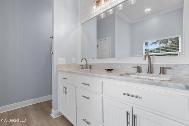 bathroom with hardwood / wood-style flooring, vanity, and crown molding