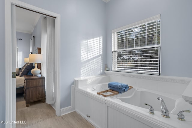 bathroom featuring crown molding, a bathtub, and hardwood / wood-style flooring