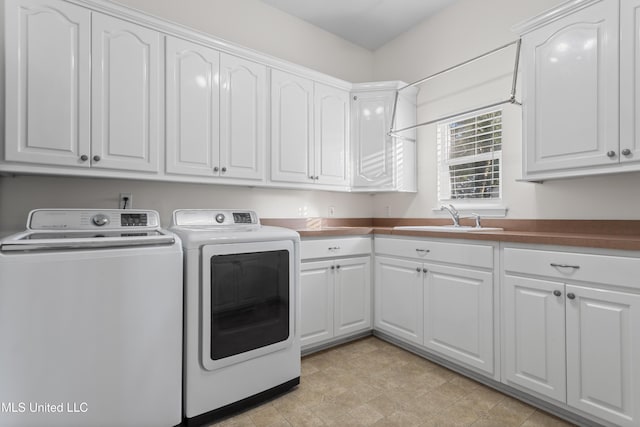 washroom with washing machine and dryer, sink, and cabinets