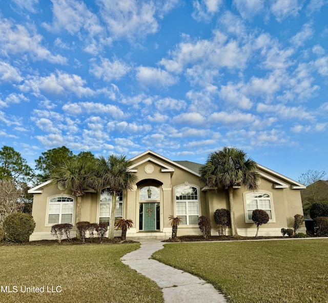 view of front of home featuring stucco siding and a front yard