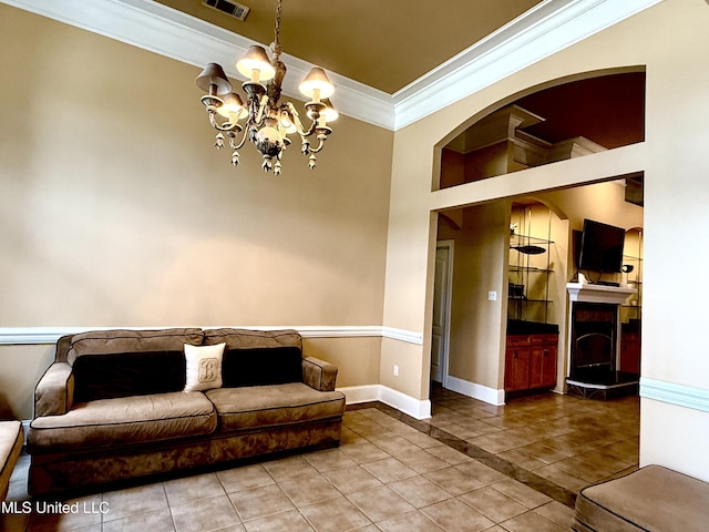 living area featuring tile patterned flooring, visible vents, baseboards, ornamental molding, and a notable chandelier