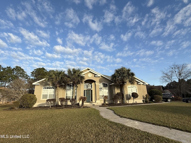 view of front of house featuring stucco siding and a front lawn